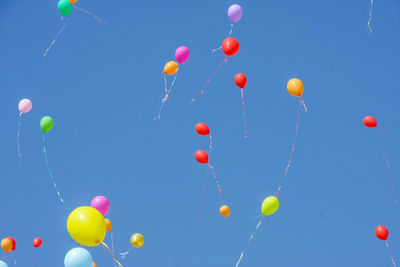 Low angle view of colorful balloons against clear sky