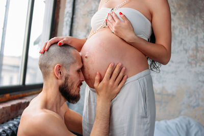 Close-up of man touching to pregnant woman abdomen