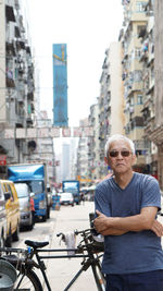 Man with bicycle on street in city