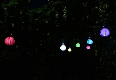 Low angle view of illuminated lanterns hanging at night