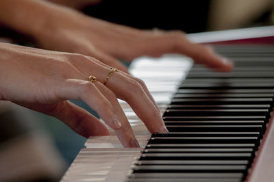 Cropped hands of woman playing piano