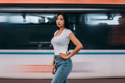 Portrait of young woman standing in train