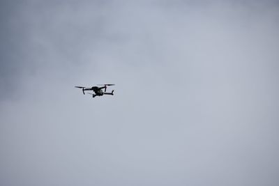 Low angle view of drone flying in sky