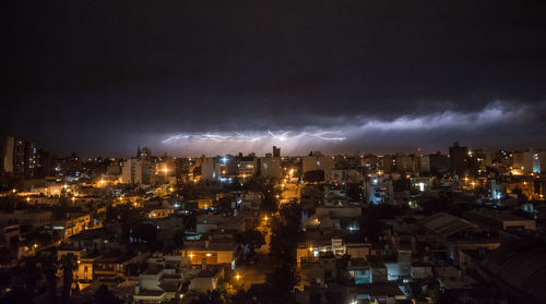 High angle view of illuminated cityscape against sky at night