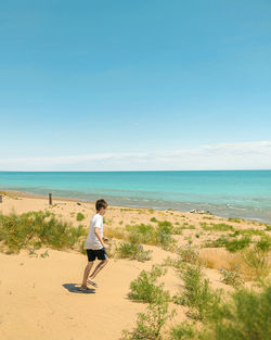 Full length of woman on beach against sky