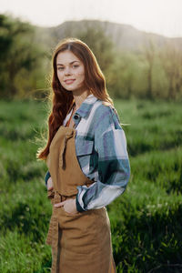 Portrait of smiling woman standing at field