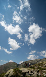 People standing on mountain against sky