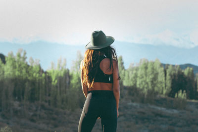 Rear view of woman standing against sky