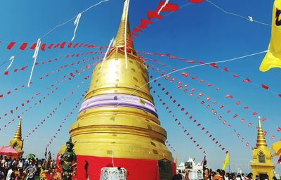 Low angle view of decorated stupas against sky