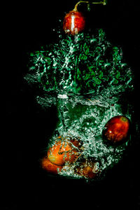 High angle view of apples in sea against black background