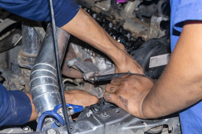 The mechanic is checking the engine.