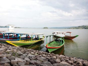 Boats moored at beach against sky