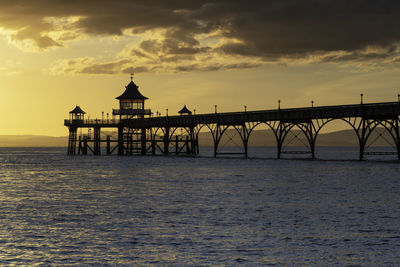 Clevedon pier silhouetted against golden sky during sunset