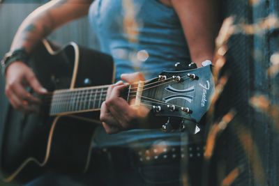 Midsection of man playing guitar