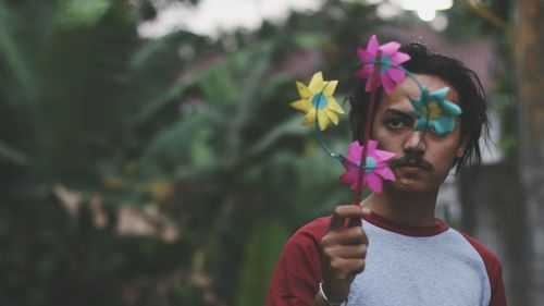 Serious man holding pinwheel toy