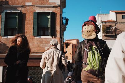 Rear view of people walking in front of building