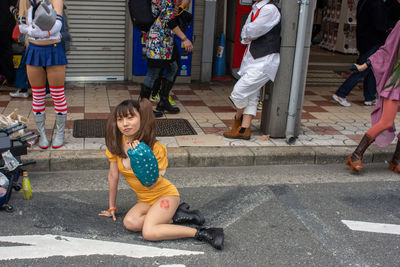 People sitting on street in city