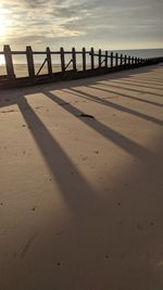 Shadow of wooden posts on beach