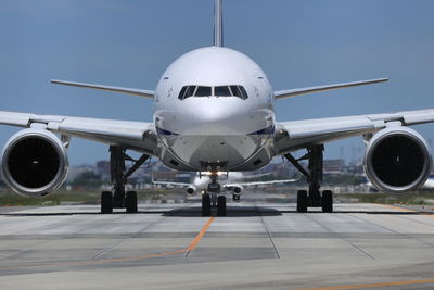 Airplane on runway against clear blue sky