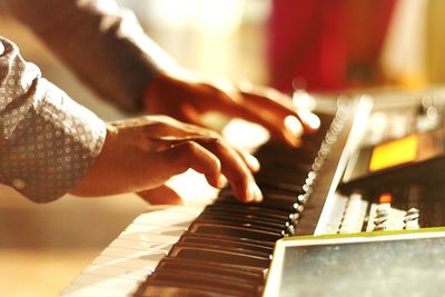 Cropped hands playing piano