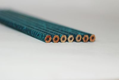 Close-up of colored pencils over white background