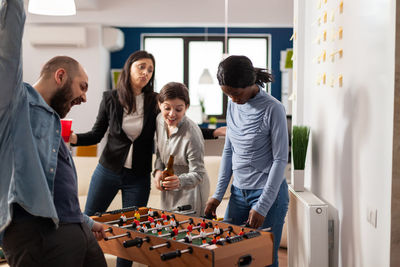 Business colleagues playing foosball at office