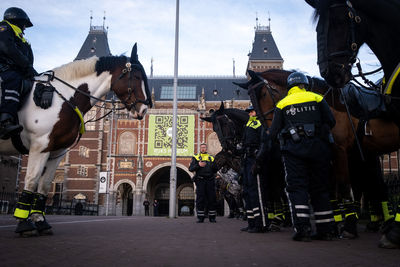 Group of people in town square against sky