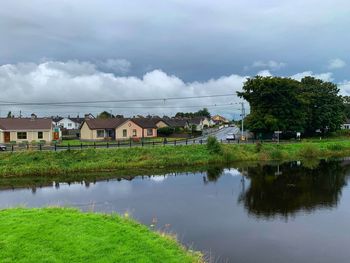 Scenic view of lake by buildings against sky