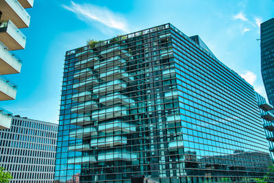 Low angle view of modern buildings in city against sky