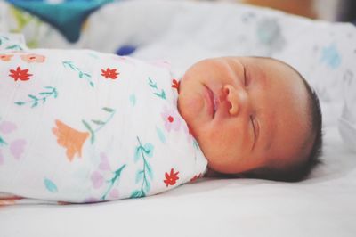 Close-up of baby sleeping on bed