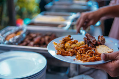 Close-up of man preparing food in plate