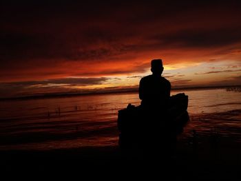 Silhouette of man sitting on beach