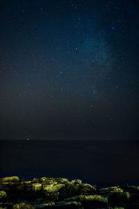 Scenic view of sea against star field at night