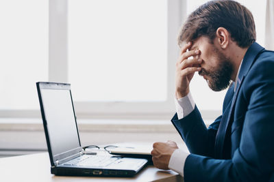 Man using mobile phone while sitting on table