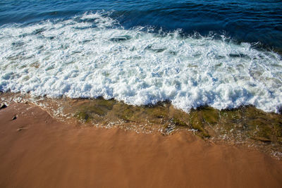 High angle view of waves rushing towards shore