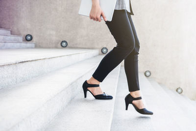 Low section of woman moving down on steps