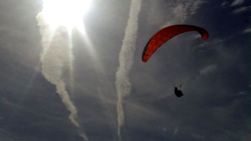 Low angle view of woman flying against sky