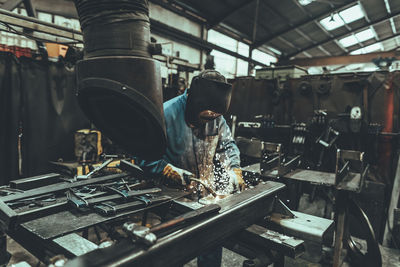 Welder welding metal in a factory