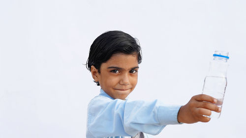 Asian school kids drink water from a bottle against the studio background. back to school, lifestyle