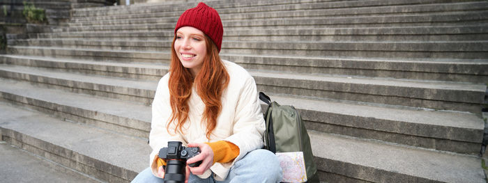 Portrait of young woman standing on steps