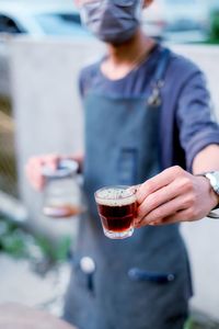 Midsection of man drinking glass