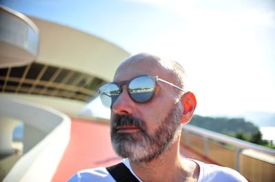 Close-up of mature man wearing sunglasses against building