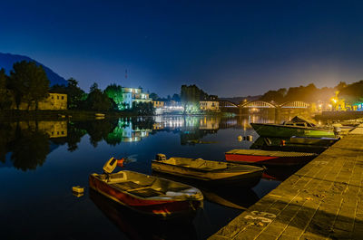 Boats moored in harbor at night