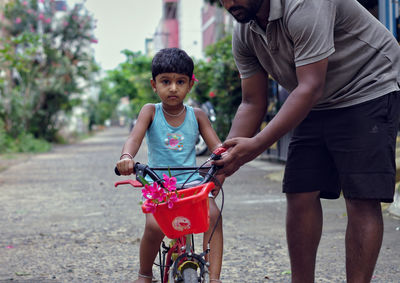 Full length of mother and daughter riding bicycle