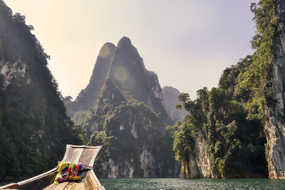 Panoramic view of people on rock by sea against sky