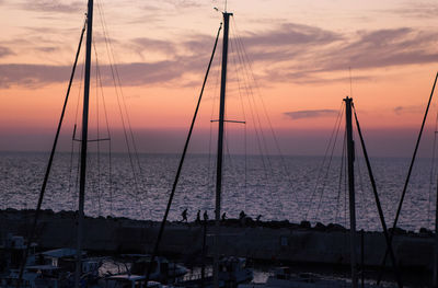 Sailboats in sea against sky during sunset