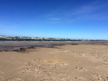 Scenic view of beach against clear blue sky