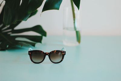 Close-up of sunglasses on glass against sea