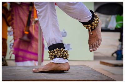 Low section of man standing on wood