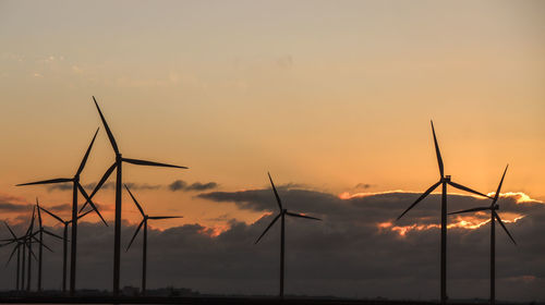 Silhouette of wind turbine against sky during sunset